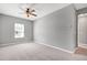 Spacious bedroom featuring neutral carpet, large window, ceiling fan and neutral paint at 3224 Wishing Well Wynd, Apex, NC 27502