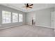 Primary bedroom with carpet, tray ceiling, ceiling fan and an ensuite bathroom at 3224 Wishing Well Wynd, Apex, NC 27502
