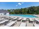 The community pool features ample seating with tables and chairs, with a sun-drenched deck ideal for relaxing at 3224 Wishing Well Wynd, Apex, NC 27502