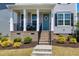 Close-up of a welcoming front porch with a blue door and decorative wreath at 3224 Wishing Well Wynd, Apex, NC 27502