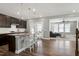 A well-lit, open-concept kitchen with a granite island, dark cabinetry, and hardwood floors at 3224 Wishing Well Wynd, Apex, NC 27502