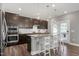 Kitchen boasts stainless steel appliances, a granite island with seating, and dark wood cabinetry at 3224 Wishing Well Wynd, Apex, NC 27502