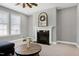 Cozy living room with fireplace, ceiling fan, comfortable seating, and bright natural light at 3224 Wishing Well Wynd, Apex, NC 27502