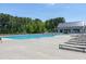 A large swimming pool surrounded by lounge chairs and trees on a sunny day at 3224 Wishing Well Wynd, Apex, NC 27502