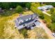 Aerial view of white house, black roof, covered porch, and surrounding landscaped yard and trees at 3281 Phillips Chapel Rd, Haw River, NC 27258