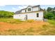 View of the home's backyard showing its white siding, black roof, and small deck area at 3281 Phillips Chapel Rd, Haw River, NC 27258