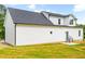 The home's backyard shows the home's white siding, new black roof, and access to a small deck at 3281 Phillips Chapel Rd, Haw River, NC 27258
