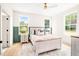 Bedroom featuring a ceiling fan, and large windows offering views of the surrounding greenery at 3281 Phillips Chapel Rd, Haw River, NC 27258
