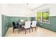 Elegant dining room featuring wainscoting, modern light fixture, and large windows offering backyard views at 3281 Phillips Chapel Rd, Haw River, NC 27258