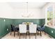 Elegant dining room with modern chandelier, green wainscoting, and plenty of natural light at 3281 Phillips Chapel Rd, Haw River, NC 27258