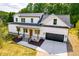 Aerial view of the home showing the white exterior, black roof, covered porch, and two-car garage at 3281 Phillips Chapel Rd, Haw River, NC 27258