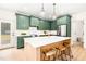 Modern kitchen features green cabinets, stainless steel appliances, and a large island with wooden stools at 3281 Phillips Chapel Rd, Haw River, NC 27258