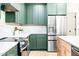 Kitchen with green cabinets, stainless steel refrigerator, and modern appliances on quartz countertops at 3281 Phillips Chapel Rd, Haw River, NC 27258