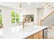 Bright living area with a view to the staircase and windows overlooking the greenery outside at 3281 Phillips Chapel Rd, Haw River, NC 27258