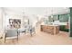 Open concept living room with light wood floors, white walls, and an adjoining kitchen with green cabinetry at 3281 Phillips Chapel Rd, Haw River, NC 27258