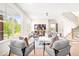 Sunlit living room with comfortable seating, view of backyard, and stairs leading to the upper level at 3281 Phillips Chapel Rd, Haw River, NC 27258