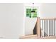 White stairwell with wood banister and black iron spindles features a striking light fixture at 3281 Phillips Chapel Rd, Haw River, NC 27258