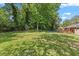 A spacious backyard features a well-maintained lawn and mature trees at 3425 Brentwood Rd, Raleigh, NC 27604