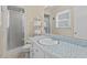Bathroom featuring tiled vanity, shower with glass door, and a neatly arranged towel rack at 3425 Brentwood Rd, Raleigh, NC 27604