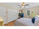 Bedroom features hardwood floors, ceiling fan, closet, a desk and comfortable bed at 3425 Brentwood Rd, Raleigh, NC 27604