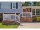 Close-up of a home's front porch with a white railing, brick facade, and inviting entryway at 3425 Brentwood Rd, Raleigh, NC 27604