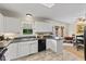 Bright kitchen features white cabinets, black countertops, and appliances, with a view to the breakfast area at 3425 Brentwood Rd, Raleigh, NC 27604