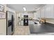 Well-lit kitchen showcasing white cabinets, a gray countertop, stainless steel appliances, and black appliances at 3425 Brentwood Rd, Raleigh, NC 27604
