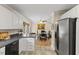 Kitchen with black counters and appliances, open to a dining area with a view to the exterior at 3425 Brentwood Rd, Raleigh, NC 27604