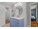 Modern bathroom featuring blue vanity with marble countertop, updated fixtures, and neutral paint at 3501 Arrowwood Dr, Raleigh, NC 27604
