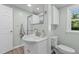 Cozy bathroom with modern vanity, framed mirror, a window, and a walk-in shower with glass doors at 3501 Arrowwood Dr, Raleigh, NC 27604