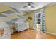 Bright Bedroom featuring a white crib, hardwood floors, geometric wall design, a window, and stylish decor at 3501 Arrowwood Dr, Raleigh, NC 27604