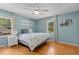 Light and airy bedroom with hardwood floors, a ceiling fan, lots of natural light, and stylish decor at 3501 Arrowwood Dr, Raleigh, NC 27604
