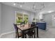 Open dining room with modern lighting, table set for four, flowing into the kitchen at 3501 Arrowwood Dr, Raleigh, NC 27604
