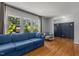 Bright living room with hardwood floors, a blue sofa, and a stylish accent wall at 3501 Arrowwood Dr, Raleigh, NC 27604