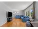 Spacious living room featuring hardwood floors, large windows, and a comfortable blue sofa at 3501 Arrowwood Dr, Raleigh, NC 27604