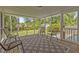 Screened porch with four chairs, a patterned rug and a view of the lawn and surrounding trees at 3501 Arrowwood Dr, Raleigh, NC 27604