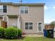Townhome backyard, featuring a grassy area, shrubs, an external door, and an air conditioning unit at 3508 Oneonta Ave, Raleigh, NC 27604