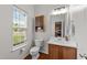 Well-lit half bath with wood floors, cabinet, and a window providing ample natural light at 3508 Oneonta Ave, Raleigh, NC 27604