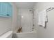 Relaxing bath and shower combo with white tile, modern fixtures, and a cabinet for storage at 3508 Oneonta Ave, Raleigh, NC 27604