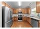 Well-lit kitchen featuring stainless steel appliances, wooden cabinets, and hardwood floors at 3508 Oneonta Ave, Raleigh, NC 27604