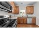 Modern kitchen with stainless steel appliances, wood cabinets, and ample countertop space at 3508 Oneonta Ave, Raleigh, NC 27604