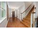 Spacious foyer featuring hardwood floors, staircase with white trim, and views to the front door at 3612 Carriage Dr, Raleigh, NC 27612