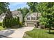 Inviting two-story home with manicured lawn, lush trees, and a driveway leading to the garage at 3612 Carriage Dr, Raleigh, NC 27612
