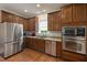 Well-equipped kitchen with stainless steel appliances, granite countertops, and dark wood cabinetry at 3612 Carriage Dr, Raleigh, NC 27612