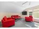 Bright living room with red sofas, stylish coffee table, and flat-screen television at 3612 Carriage Dr, Raleigh, NC 27612