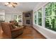 Inviting living room featuring a stone fireplace, hardwood floors, and large windows with a wooded view at 3612 Carriage Dr, Raleigh, NC 27612