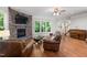 Cozy living room with a corner stone fireplace, hardwood floors, and views to stairs and front door at 3612 Carriage Dr, Raleigh, NC 27612