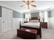 Cozy main bedroom with soft carpet, ceiling fan, and decorative wainscoting at 3612 Carriage Dr, Raleigh, NC 27612