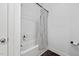 This is a white tub/shower combo bathroom with wood look floors and a striped shower curtain at 380 Perdues Rd, Louisburg, NC 27549