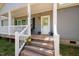 Inviting front porch with a welcoming door, decorative wreath, and blooming potted flowers at 380 Perdues Rd, Louisburg, NC 27549